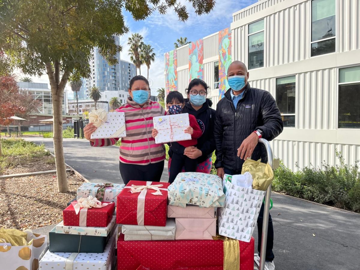 An AEG employee delivers a wagon full of presents to a family in need. 