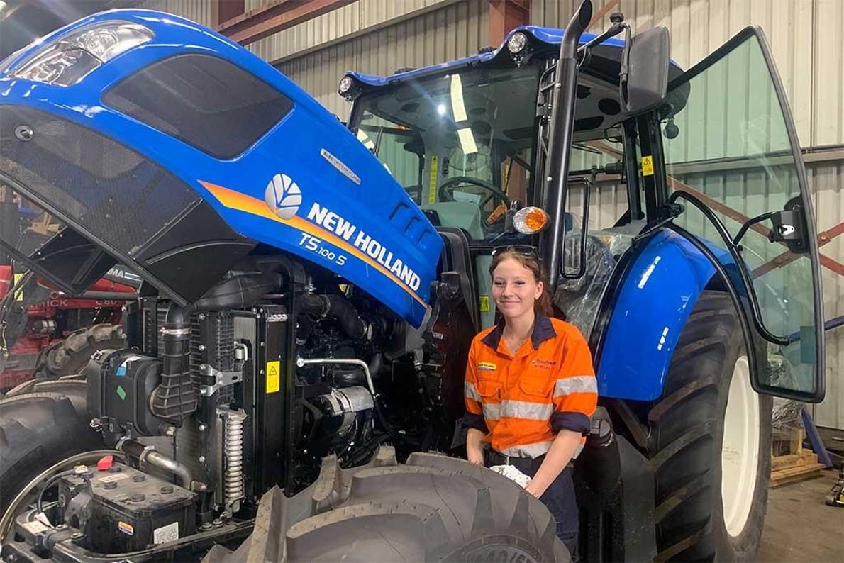 New Holland is fostering careers in agriculture for young women across Australia woman standing in front of equipment