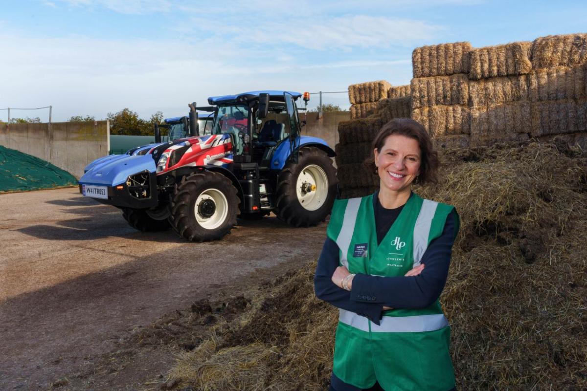 CNH is proud to be partnered with Bennamann in pursuit of sustainable excellence and a bright future for farmers across the globe. Person smiling with their arms folded, stood in front of a tractor and hay bales