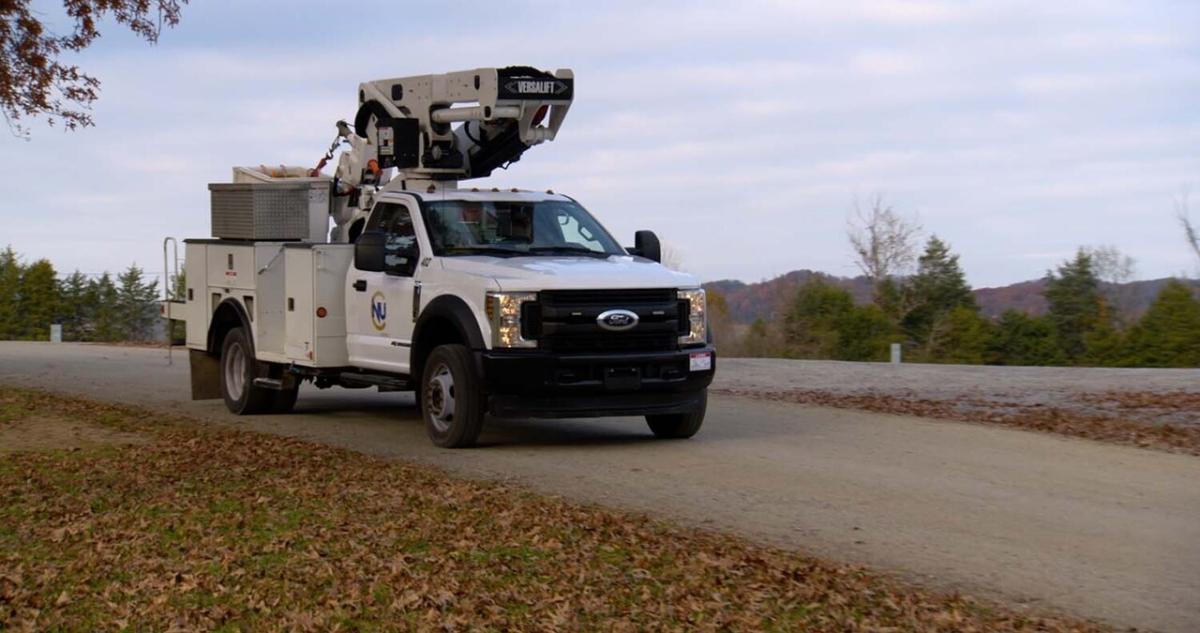 A Newport Utilities bucket truck on a road