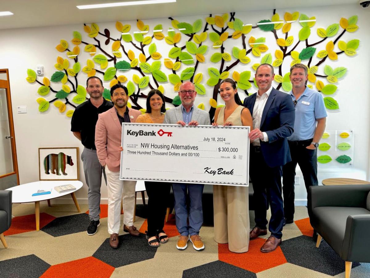 A group of people holding a large cheque