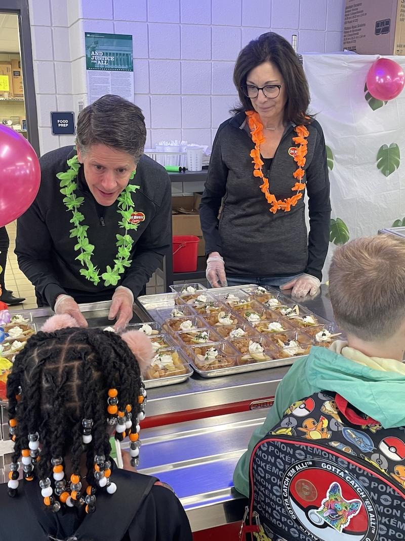 Del Monte Foods team members John Fusco and Sheri Caplan volunteer to hand out samples of a new school recipe using baked Del Monte® sliced pears at Pittsburgh Minadeo PreK-5.