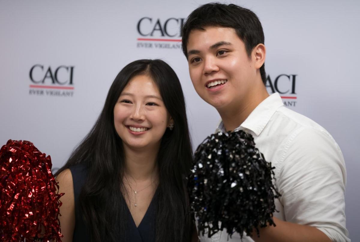 CACI interns display their company spirit on National Intern Day. Two people at CACI's National Intern Day celebration
