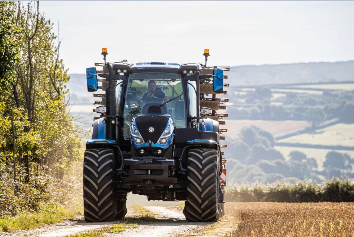 A tractor driving on a path next to a field.