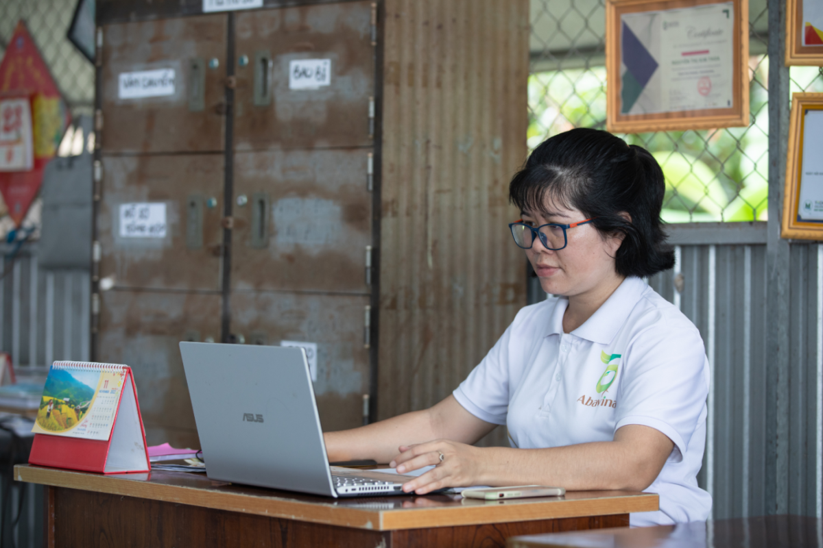 Nguyen Thi Kim Thoa in an office working on a laptop computer