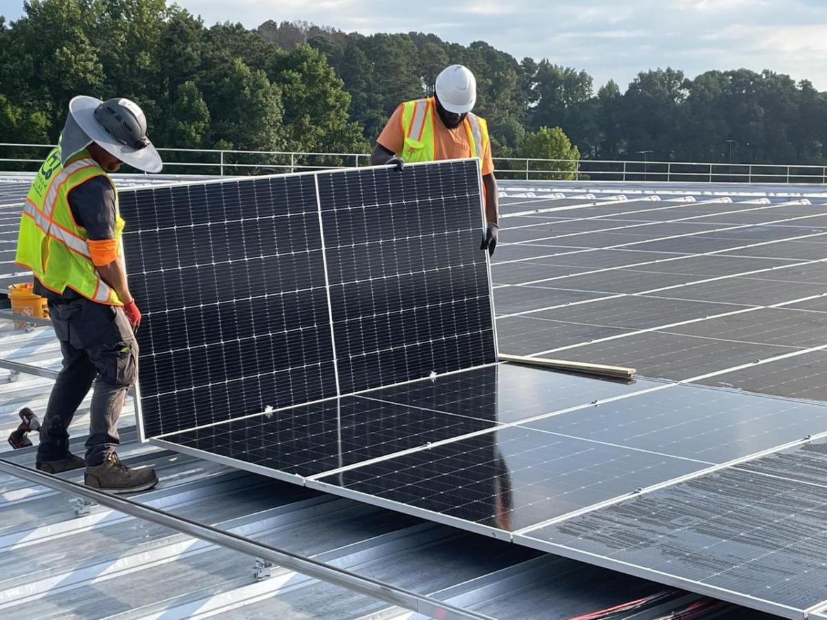 Workers installing solar panels on roof of Southwire's North Campus plant