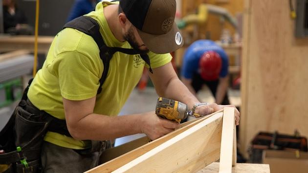 A person joining wood pieces in a workshop.