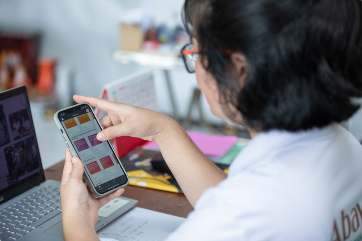 Nguyen Thi Kim Thoa in an office looking at her cellphone