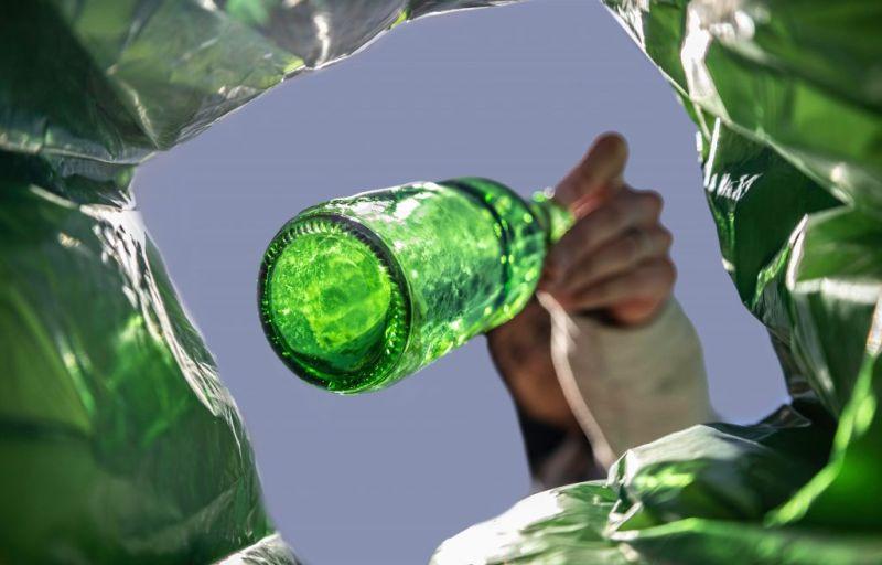 view of glass bottle being thrown in bag