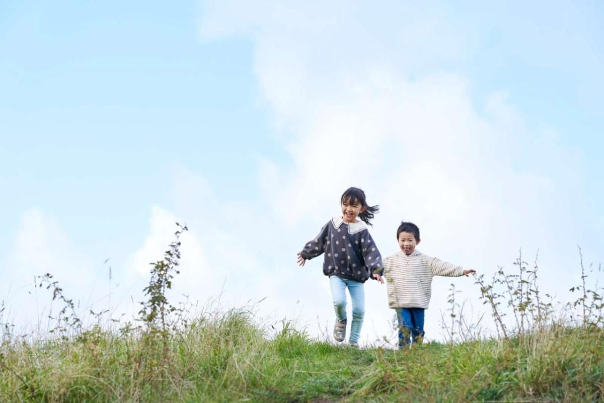 Two children running on grass