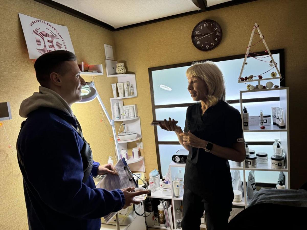 A woman and a man smile and talk in a cosmetics studio.