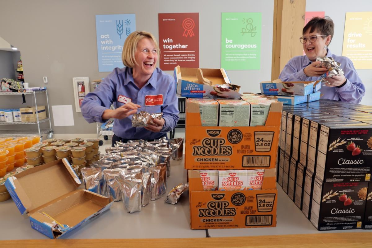 Employees of Post Consumer Brands pack bags of food