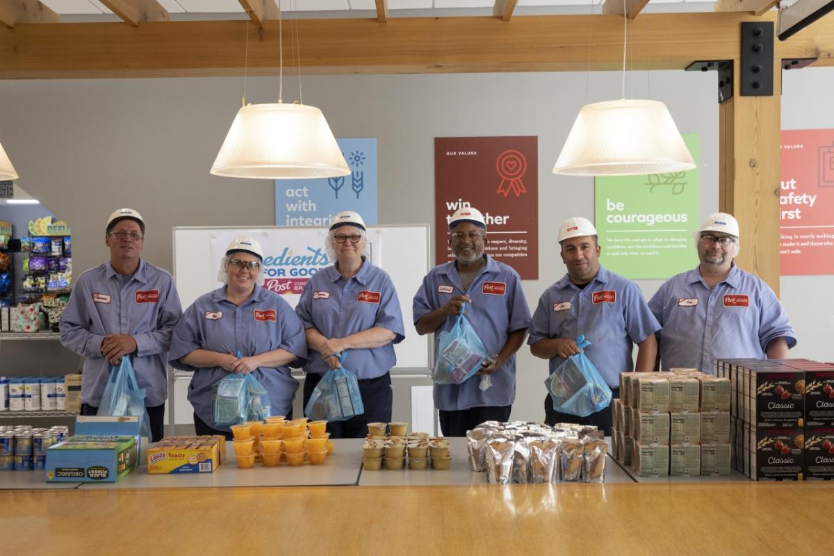 Employees of Post Consumer Brands pack bags of food