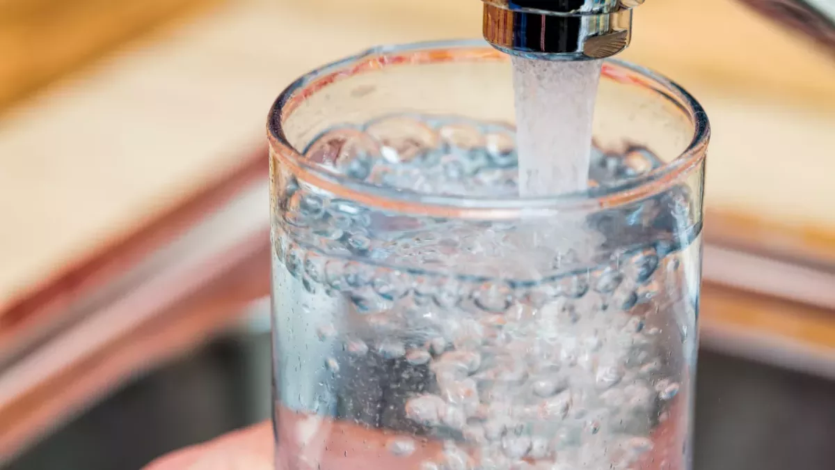 Faucet nearly filled glass of water.