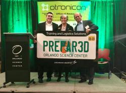 Lockheed Martin Vice President of Engineering & Technology Tom Mirek and Prepar3D Engineering Project Manager Adam Breed present Prepar3D licenses to Orlando Science Center CEO JoAnn Newman at the 14th annual Otronicon commemorating the donation.