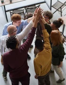 Group of eight people with hands clasped.