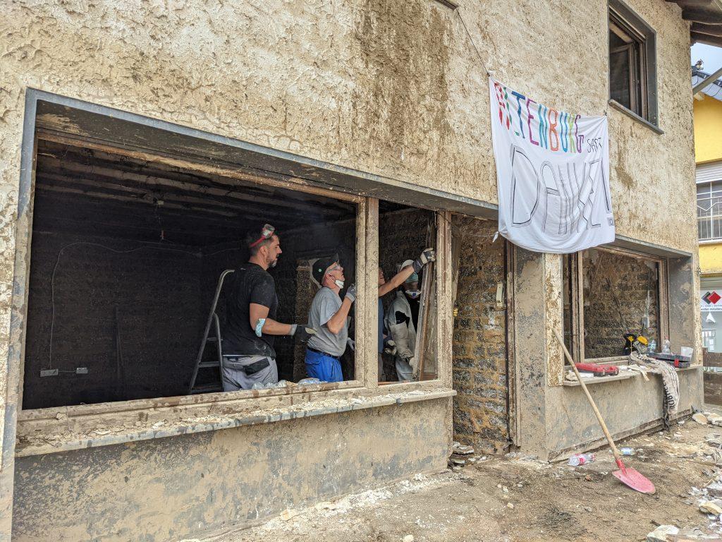employees rebuilding home destroyed by flooding