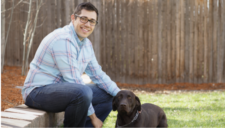 Person sitting outside and petting a dog