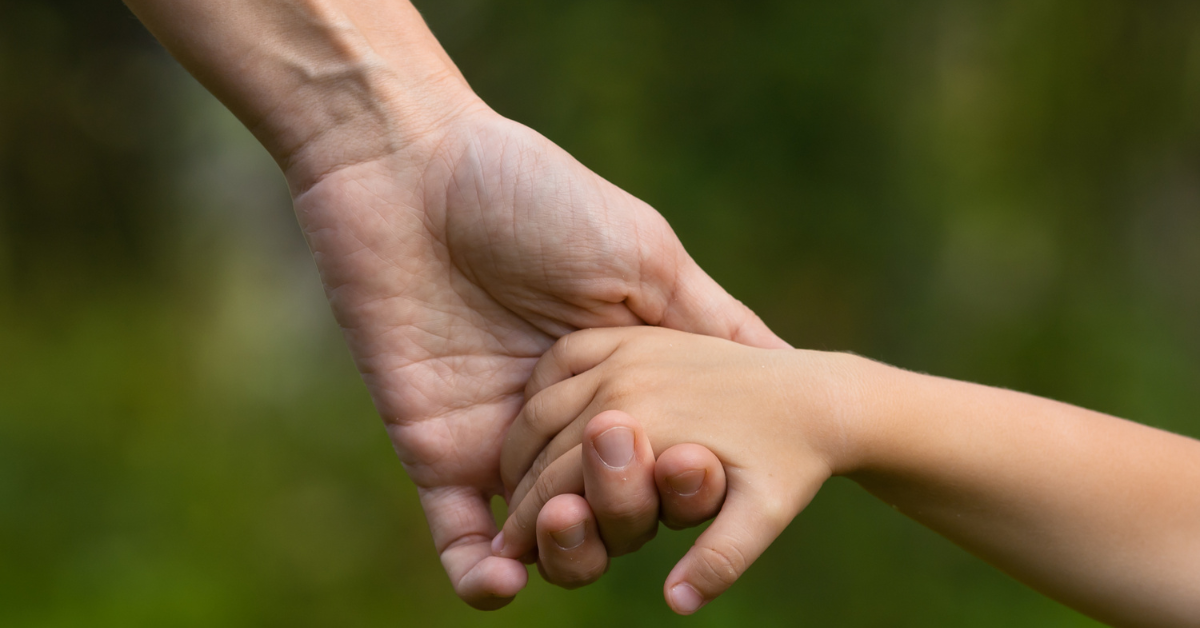 A child holding an adult's hand