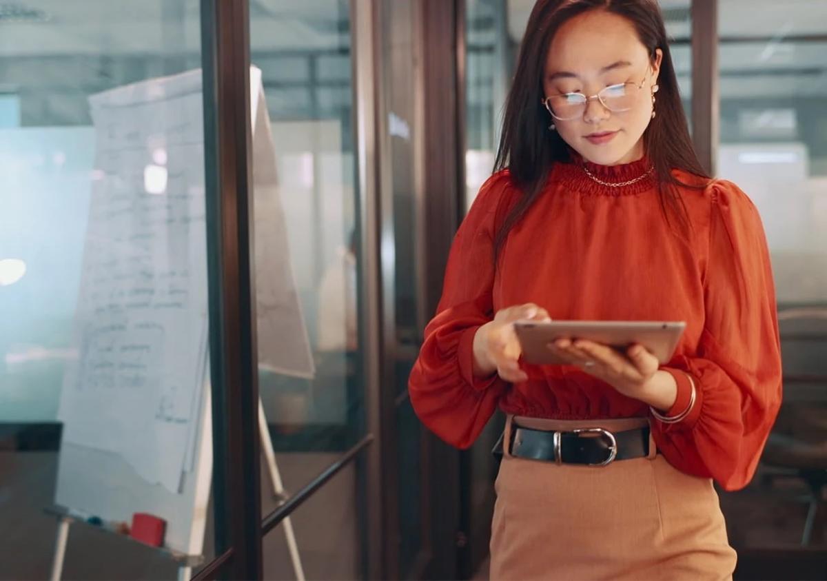 A person wearing a bright colour blouse, using a tablet PC