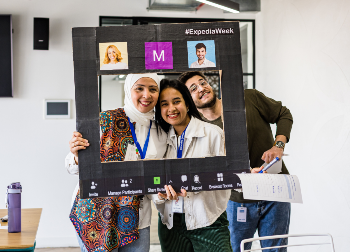 Three people using a social media photo prop