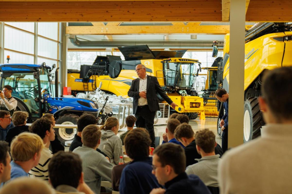 Students listening to a speaker while they await the start of the plant tour