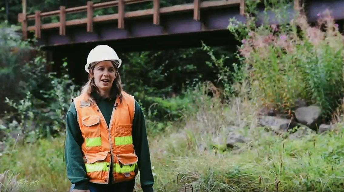 Portia Leigh in hard hat standing near a short bridge.