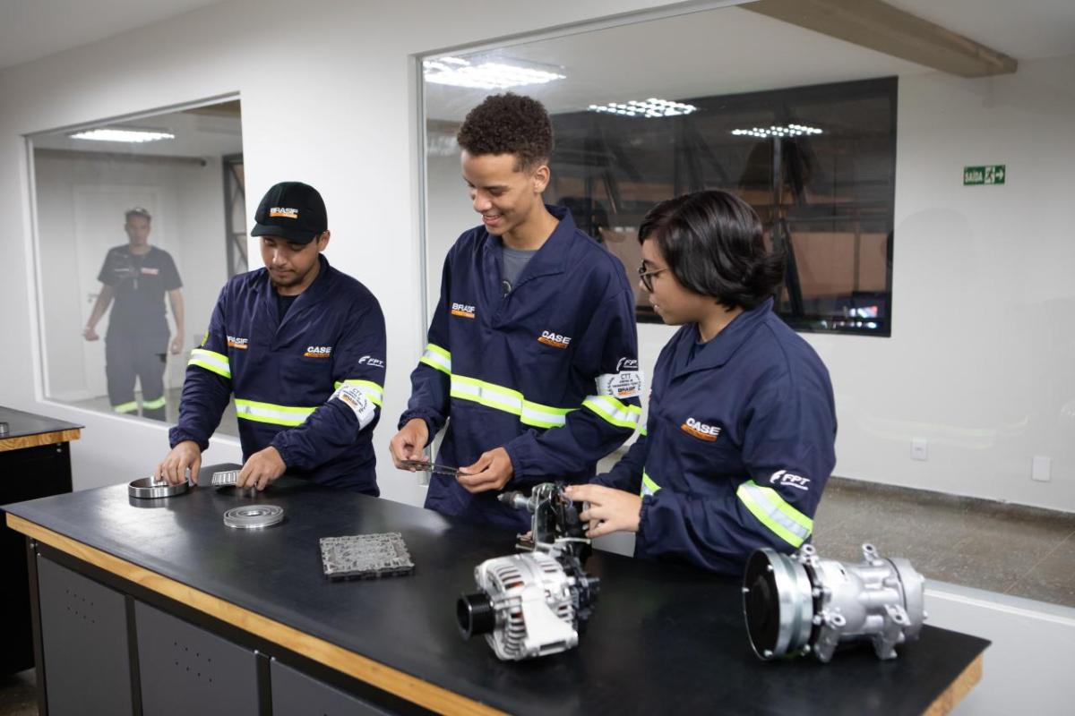 Three people stood at a table looking at mechanical components