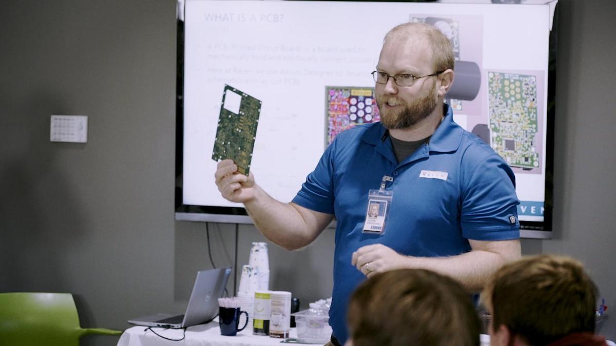 Presenter showing off circuit board