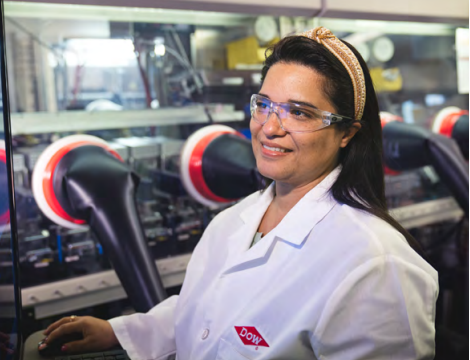 A person in white lab coat smiling to the side.