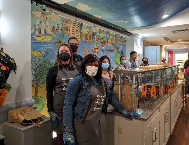 A group of volunteers posed wearing matching aprons.