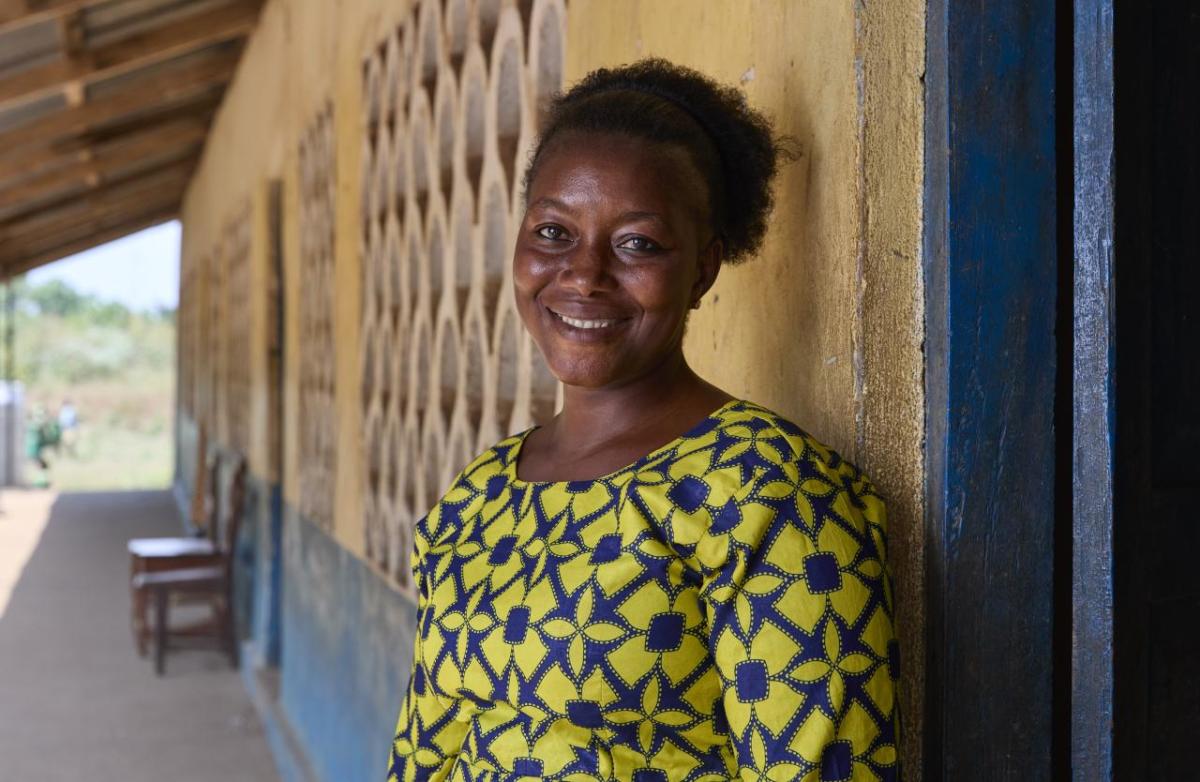 Photo: Nigel Barker/CARE Portrait photo of Mabinty in front of the school she teaches at.