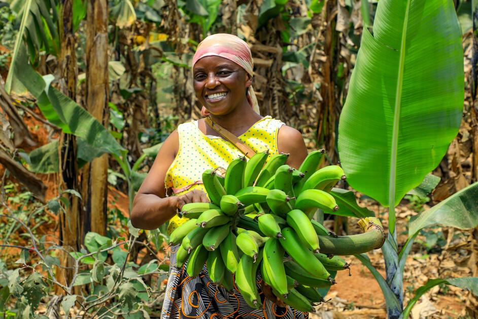 She Feeds the World program participant in Uganda. © 2022 CARE A farmer holding bananas