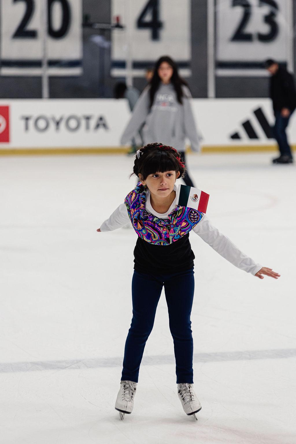 A young girl from 24 Degrees of Color skates on the ice in an outfit representing her heritage. Photo credit: Jason C Williams Photography