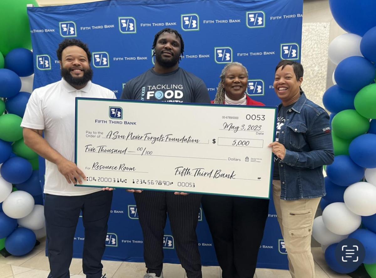 Four people holding a large Fifth Third Bank check