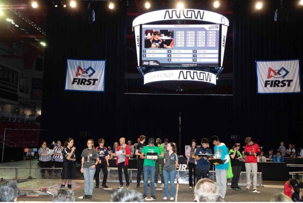 people stood in front of a crowd at the FIRST Robotics Regional Competition in Colorado
