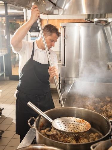 Chef preparing food at a stove.