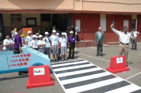 FedEx volunteers (in purple t-shirts) help teach kids in India about road safety A group of people about to enter a crosswalk