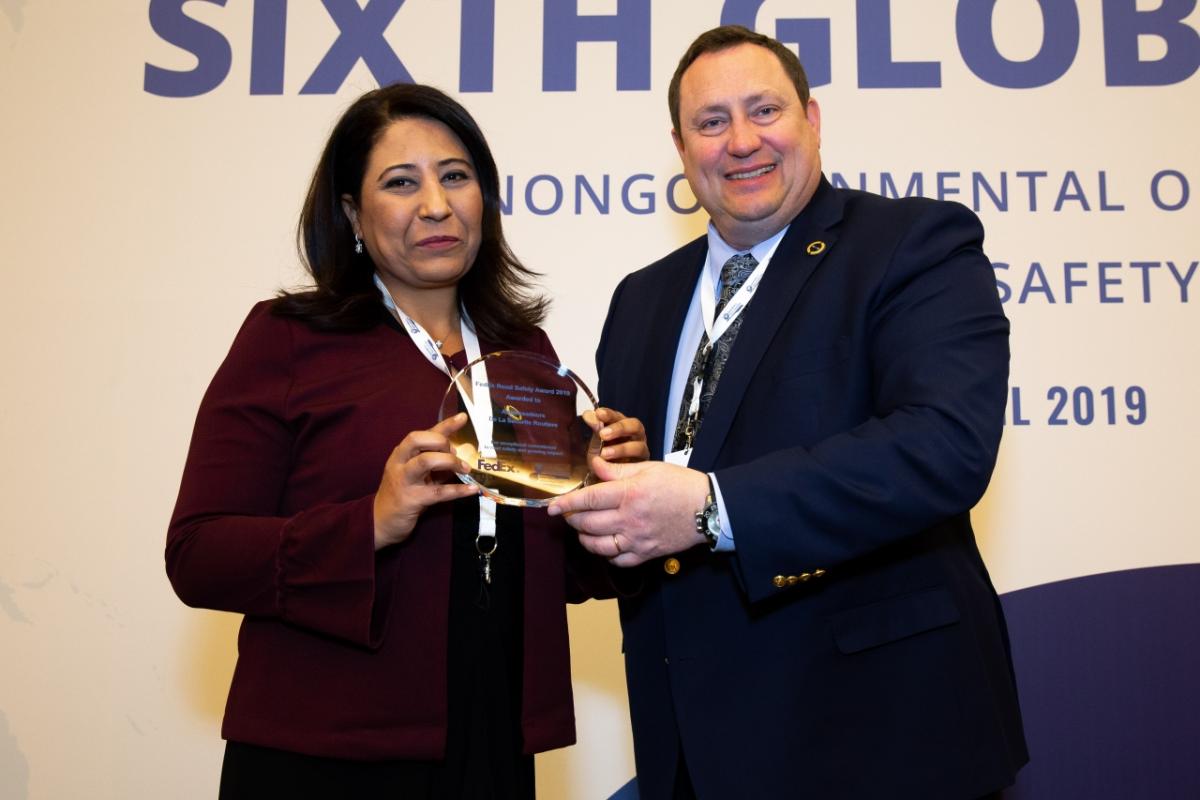A man and woman posing with an award
