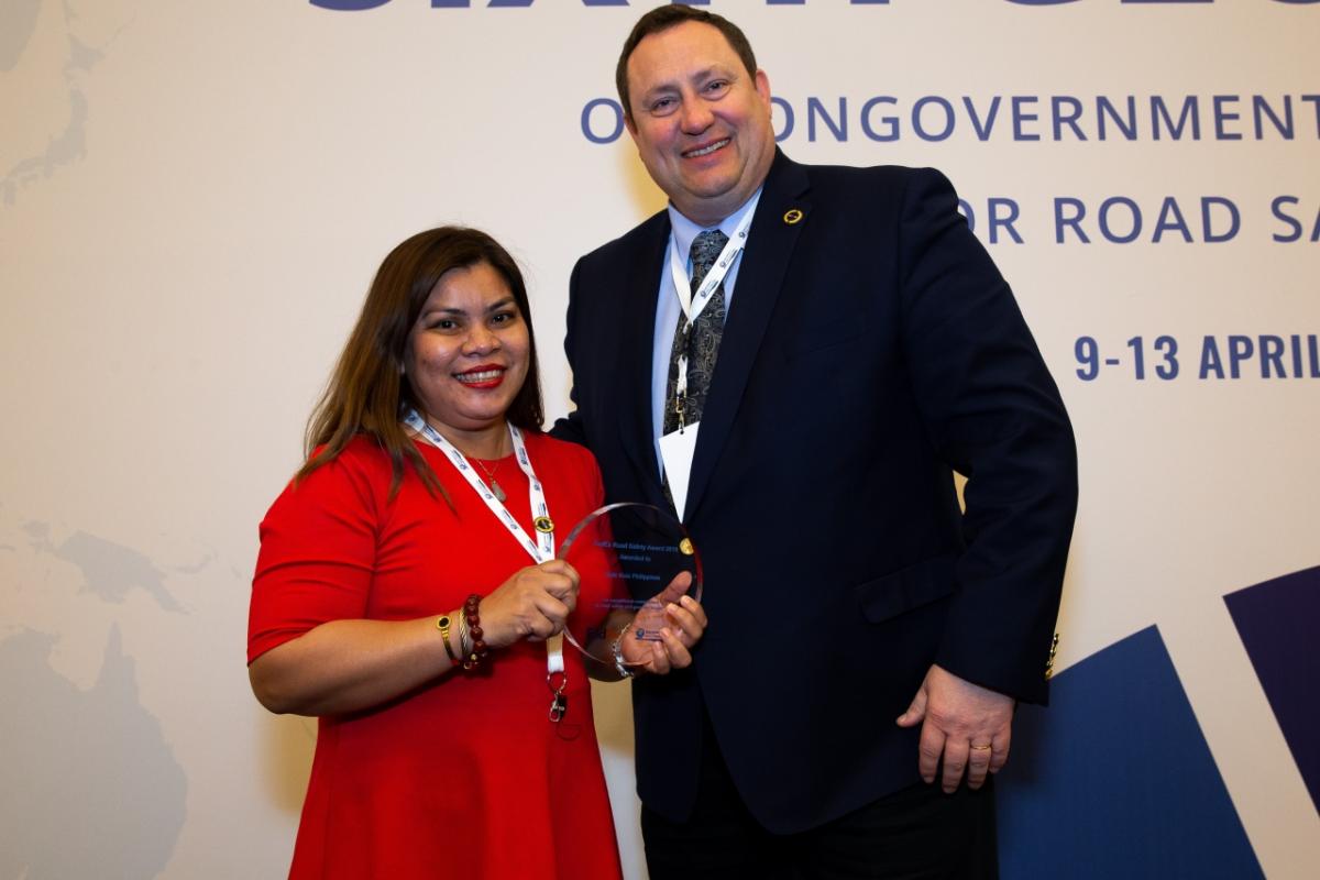 A man and woman posing with an award