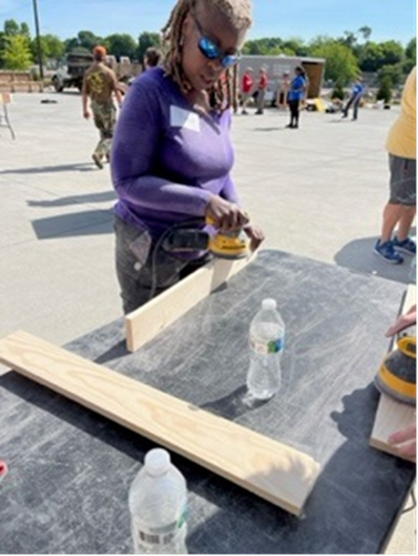 Aflac employee sanding a piece of wood