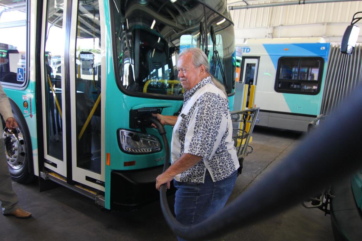 Dave Davis, chair of the Santa Barbara MTD Board of Directors, begins to charge one of the agency's new buses.