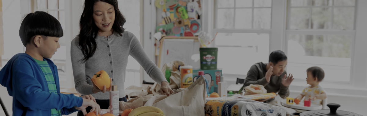 people in a kitchen unpacking a shopping bag