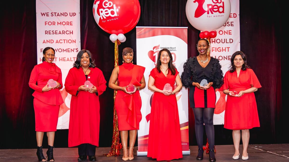 Six women wearing red, each holding an award.
