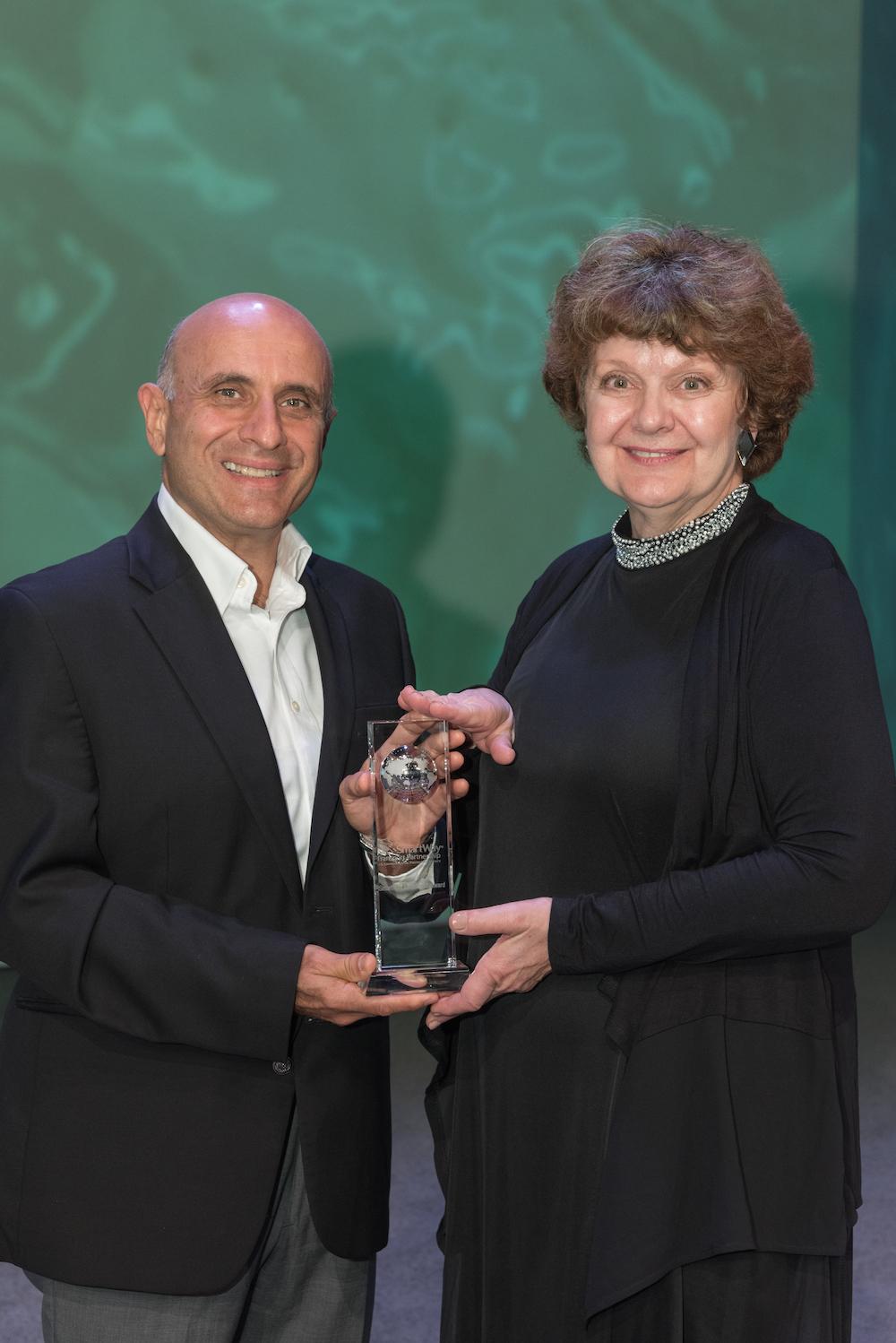 Stelios Chrysandreas, Kimberly-Clark’s North American transportation manager, receives the company’s 10th SmartWay Excellence Award from Cheryl L. Bynum, National Program Director, SmartWay Partnership.
