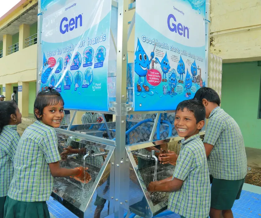 School students washing their hands under a running tap from the AquaTower system