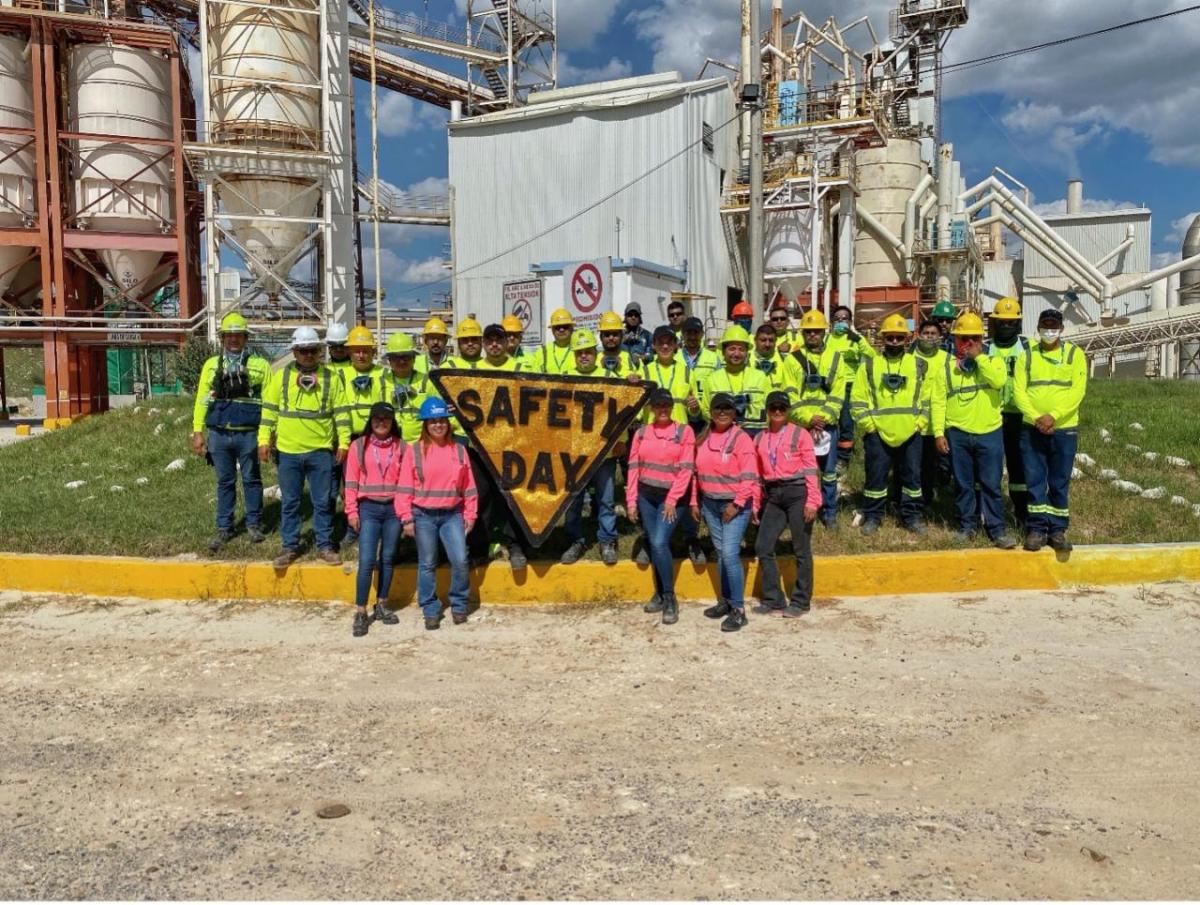 Group of employees stood around a sign that reads 'Safety day'