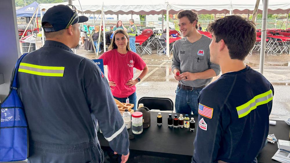 Refining Engineers Abby Sinischo and Holland vanZon chat with coworkers who stopped by their booth during the 2025 Safety Fair. " "