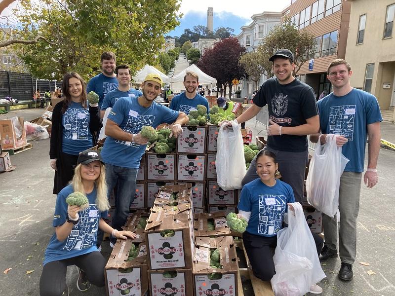 Volunteers pose with boxes of food at a food bank