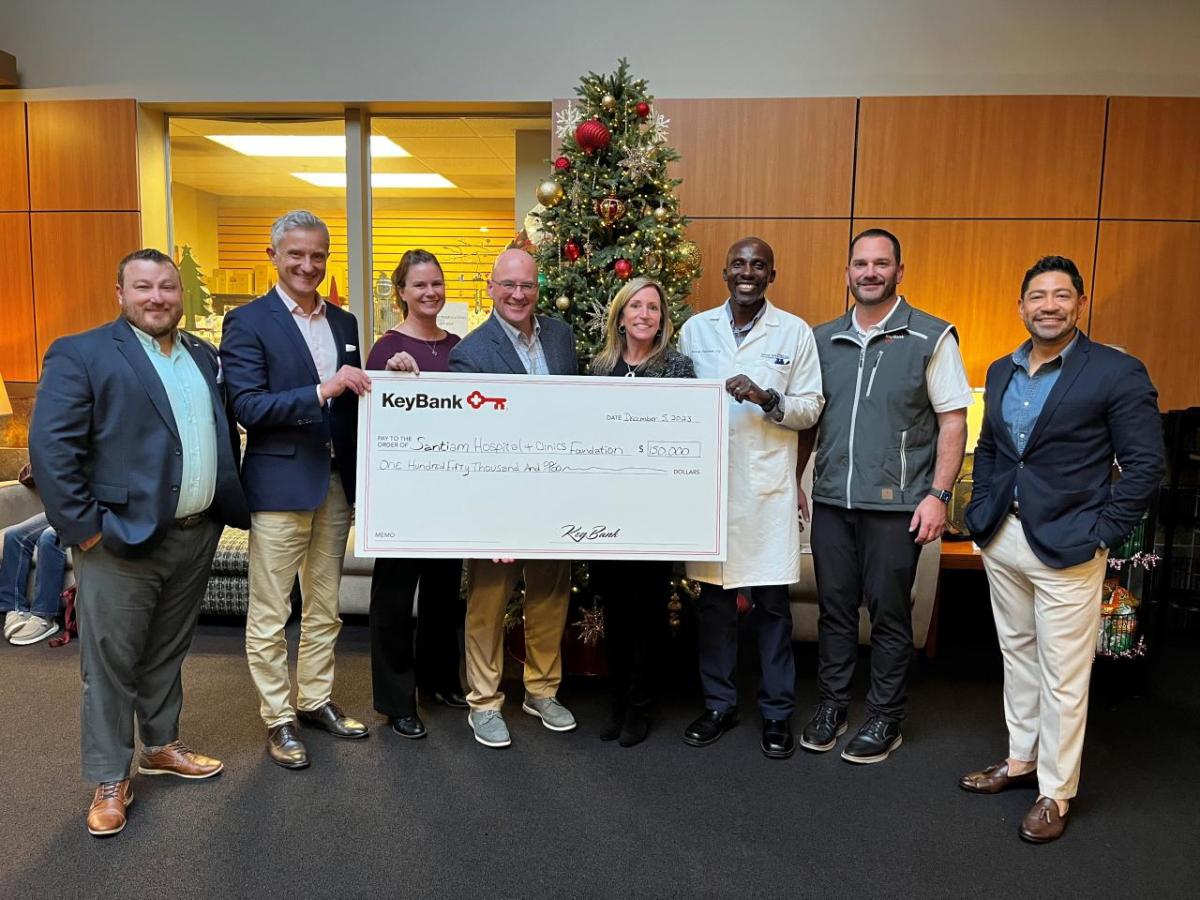 People standing together, holding a check from KeyBank